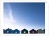 Beach huts in a row against blue skies by Assaf Frank